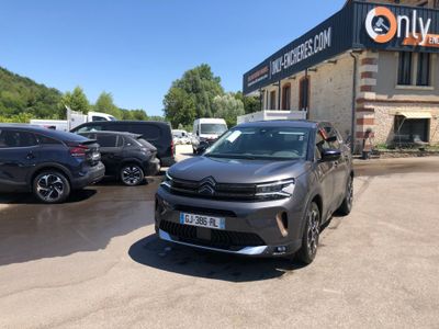 the car is parked in front of a building with many cars parked in front of it