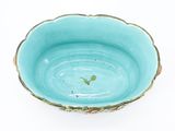 a blue bowl with a gold rim on a white surface