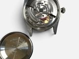 a close up of a watch on a white surface