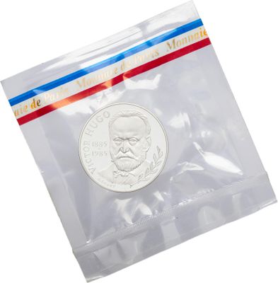 a close up of a coin in a plastic bag on a white background