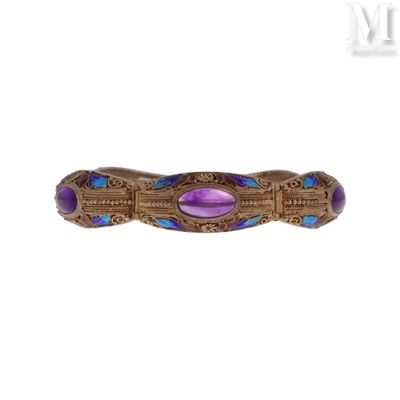 un gros plan d'une bague violette et bleue sur fond blanc