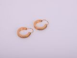 une paire de boucles d'oreilles en or sur fond blanc