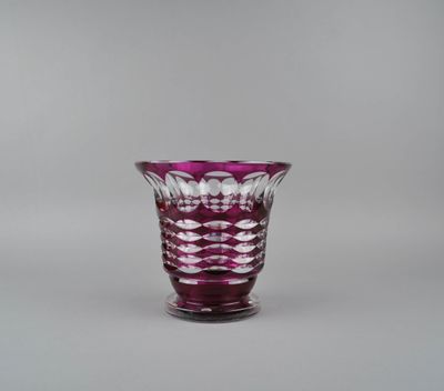 purple glass vase sitting on a table against a gray background