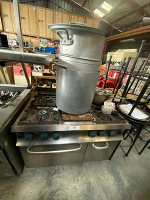 pots and pans are stacked on top of a stove in a kitchen
