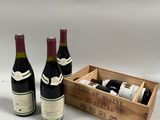 trois bouteilles de vin dans une caisse en bois sur fond blanc