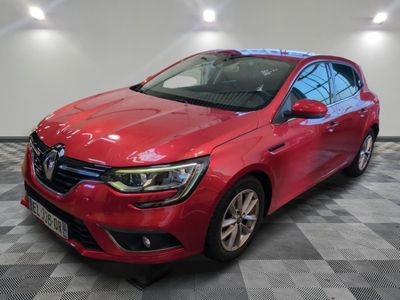 une voiture rouge est garée dans une pièce au sol en damier