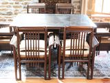 une table et des chaises dans une pièce avec un mur en pierre en arrière-plan