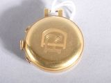 a small gold pocket watch on a white surface