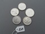 four quarters of silver coins with a price tag on a gray surface