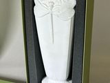 a white vase in a green box on a table