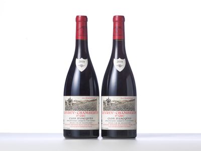 two bottles of red wine sitting on top of a table