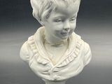 porcelain bust of a boy with a collared shirt on a pedestal