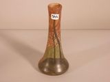 a small vase with a tree on it on a table