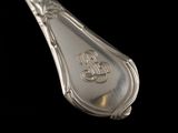 a silver spoon with a monogram on it on a black background
