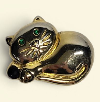 a gold and silver cat brooch with green eyes