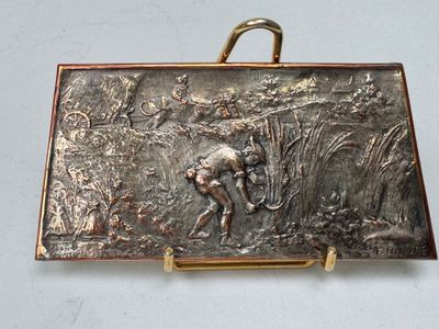 une plaque métallique sur laquelle figure la photo d'un homme dans un champ