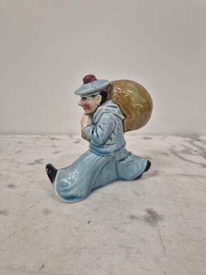 une petite figurine représentant une femme portant un sac