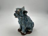 a small figurine of a cow sitting on a white surface