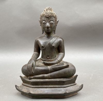 statue of a person sitting in a lotus position on top of a table