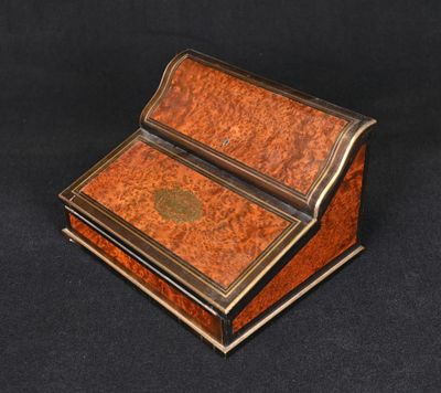 a small wooden writing desk with a black background