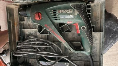 une boîte contenant une perceuse et une cordelette
