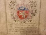a plaque on the wall of a building with a coat of arms on it