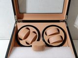 une boîte ouverte contenant deux montres, posée sur une surface blanche
