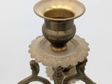 a small brass candle holder on a white background