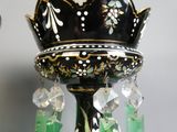 un vase noir et vert auquel sont suspendues des perles de cristal