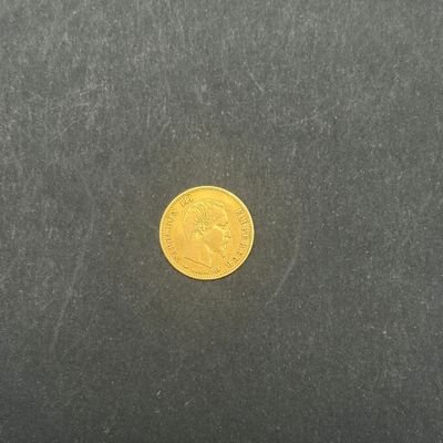 gros plan d'une pièce d'or sur une surface noire