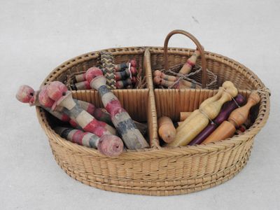 un panier en osier rempli de différents types de jouets en bois