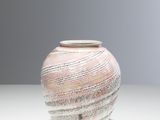 un vase blanc et rose posé sur une table