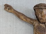 a wooden statue of a man with a cross on it