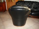 a black leather chair and a black leather couch in a living room