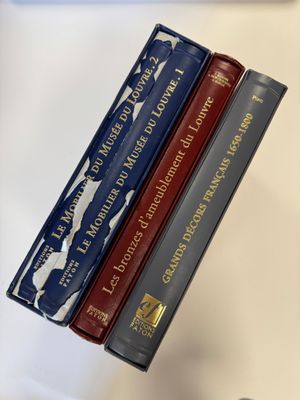 trois livres sont empilés sur une table