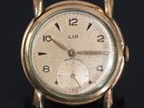a gold clock that is sitting on a black surface