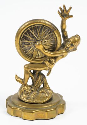 figurine en laiton représentant un homme tenant une roue, posée sur un socle
