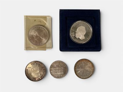 several coins are sitting in a black box on a white surface