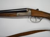 a rifle with a wooden handle and a leather strap