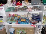 a white shelf with lots of toys on top of it