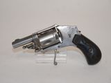 an old revolver on a clear stand on a white surface