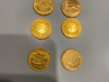 quatre pièces d'or posées sur une surface blanche