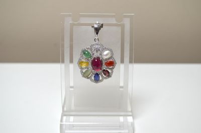 Un pendentif en argent serti au centre d'un rubis cabochon o…