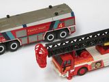 deux camions de pompiers miniatures posés l'un à côté de l'autre sur une surface blanche