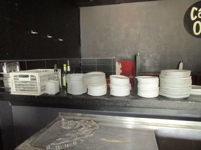 many plates and cups on the counter in the kitchen