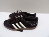 black and white adidas sneakers with brown laces on them