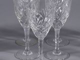 three clear wine glasses sitting on top of a table next to each other