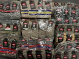 many bags of clothing wrapped in plastic on top of each other