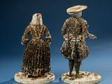 two figurines of a man and a woman dressed in traditional clothing