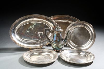 quatre assiettes en argent et une théière en argent posées sur une table